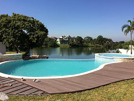 Alberca infinita con vista a la laguna y deck de madera
