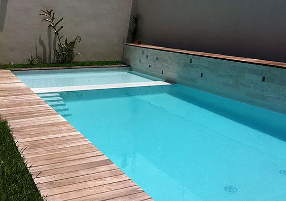 Alberca de agua turquesa con andador de madera