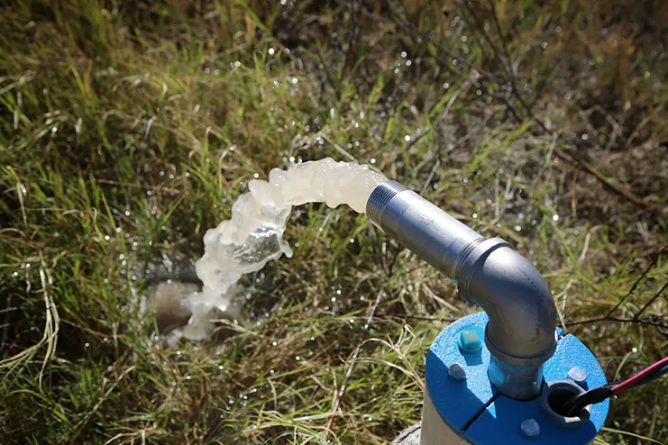 Tubo descargando agua sobre el pasto